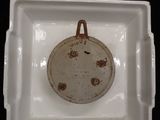 a white plate with a brown lid and a brown handle
