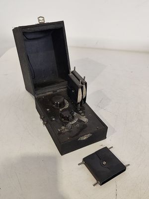 une petite boîte noire contenant un appareil photo, posée sur une table