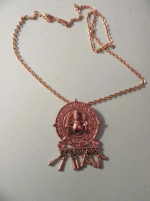 un gros plan d'un collier posé sur une assiette, avec une chaîne