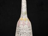 a white vase with a pink and yellow design on it