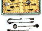 Plusieurs cuillères en argent et cuillères-cuillères se trouvent dans une boîte