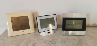 trois horloges différentes posées les unes à côté des autres sur une table