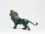 une statue de lion posée sur une surface blanche