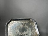 two silver trays sitting next to each other on top of a table