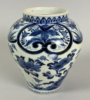 a blue and white vase with a face on it