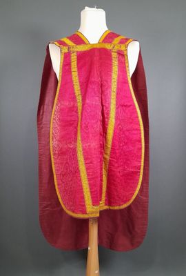 une robe rose et jaune avec une cape rouge sur un mannequin