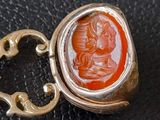 an image of a gold ring with a carnel stone in the center