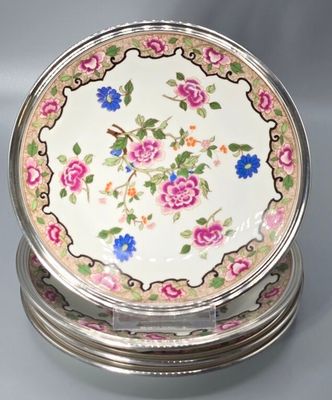 trois assiettes ornées de fleurs, posées sur une table