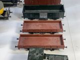 several toy trains are lined up in a row on a white surface