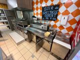 a restaurant kitchen with a checkered wall and stainless steel counter tops
