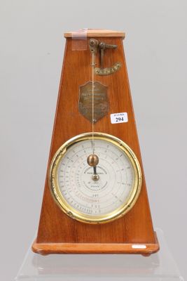 une horloge en bois sur laquelle est fixé un baromètre en laiton