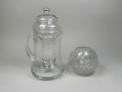 a glass pitcher and a glass ball on a table