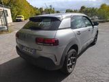 the rear end of a silver car parked in a parking lot