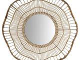 Le miroir est en rotin et possède un cadre circulaire.