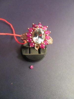 a pink bead and a gold ring on a black surface