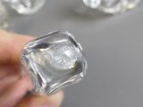 une personne tenant un bloc de verre sur lequel est représenté un visage