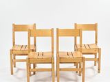 trois chaises en bois assises l'une à côté de l'autre sur une surface blanche