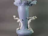 a blue vase with flowers in it sitting on a table