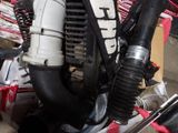 une image représentant un moteur de moto auquel est raccordé un tuyau