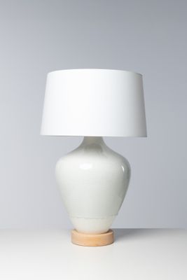 une lampe de table blanche surmontée d'un abat-jour blanc