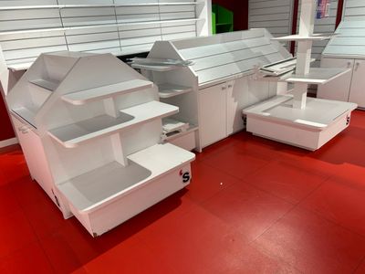 de nombreuses étagères blanches dans un magasin au sol rouge