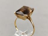 a close up of a gold ring with a smoky quartz stone in it