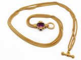 une chaîne en or avec un pendentif orné d'une pierre violette
