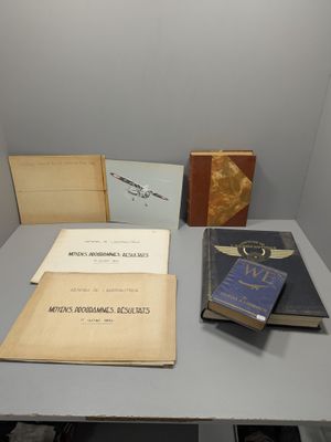 Plusieurs livres sont posés sur une table devant un mur gris.