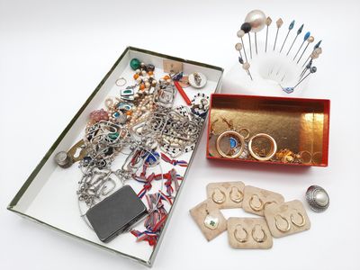 une boîte remplie de bijoux variés posée sur une surface blanche