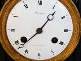 a gold clock with roman numerals on the face