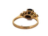 an image of a close up of a gold ring with a black stone