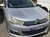 l'avant d'une Citroën argentée garée sur un parking à côté d'une camionnette blanche