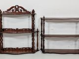 pair of antique wooden shelves with ornate carvings on each shelf
