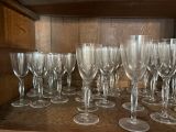 de nombreux verres à vin vides posés sur une étagère en bois