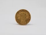 a gold coin on a white surface with a white background