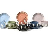 several cups and saucers are lined up on a white surface