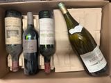 three bottles of wine in a cardboard box on a table