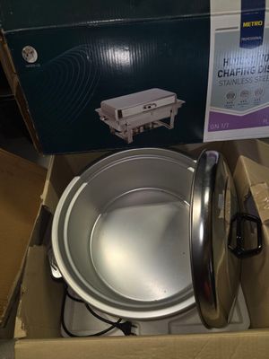 une boîte posée par terre, contenant une casserole