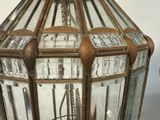 a glass lantern hanging from the ceiling on a table