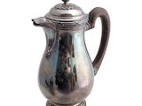 a silver coffee pot with a handle on a white background