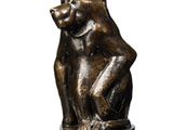 a bronze statue of a bear sitting on a base