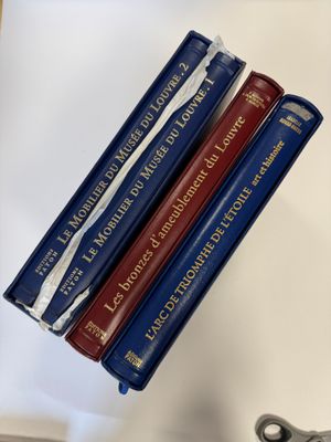 trois livres sont empilés sur une table