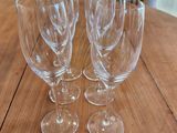 quatre verres à vin vides posés sur une table en bois