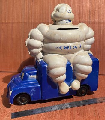 un camion jouet bleu sur lequel est assis un gros homme