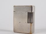 a silver lighter sitting on top of a white surface
