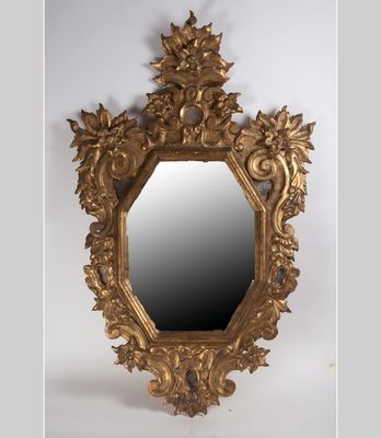 un miroir doré richement décoré de fleurs et de feuilles sur fond blanc