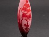 a red vase with a snake on it on a black surface