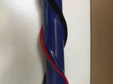 a blue tube with a red handle on a white surface