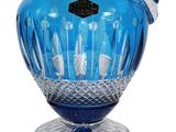 a blue glass pitcher with a handle on a stand