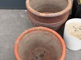 deux grands pots en terre cuite posés l'un à côté de l'autre par terre